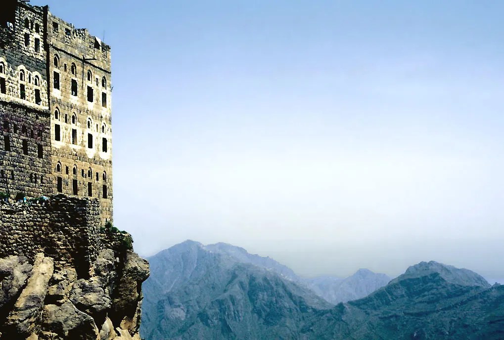 Traditional Yemeni mountain village built on a cliff edge — representative of Tawzan's setting